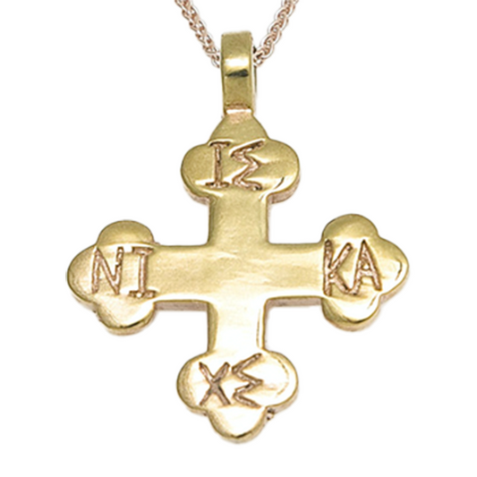 Gold cross pendant on a white background