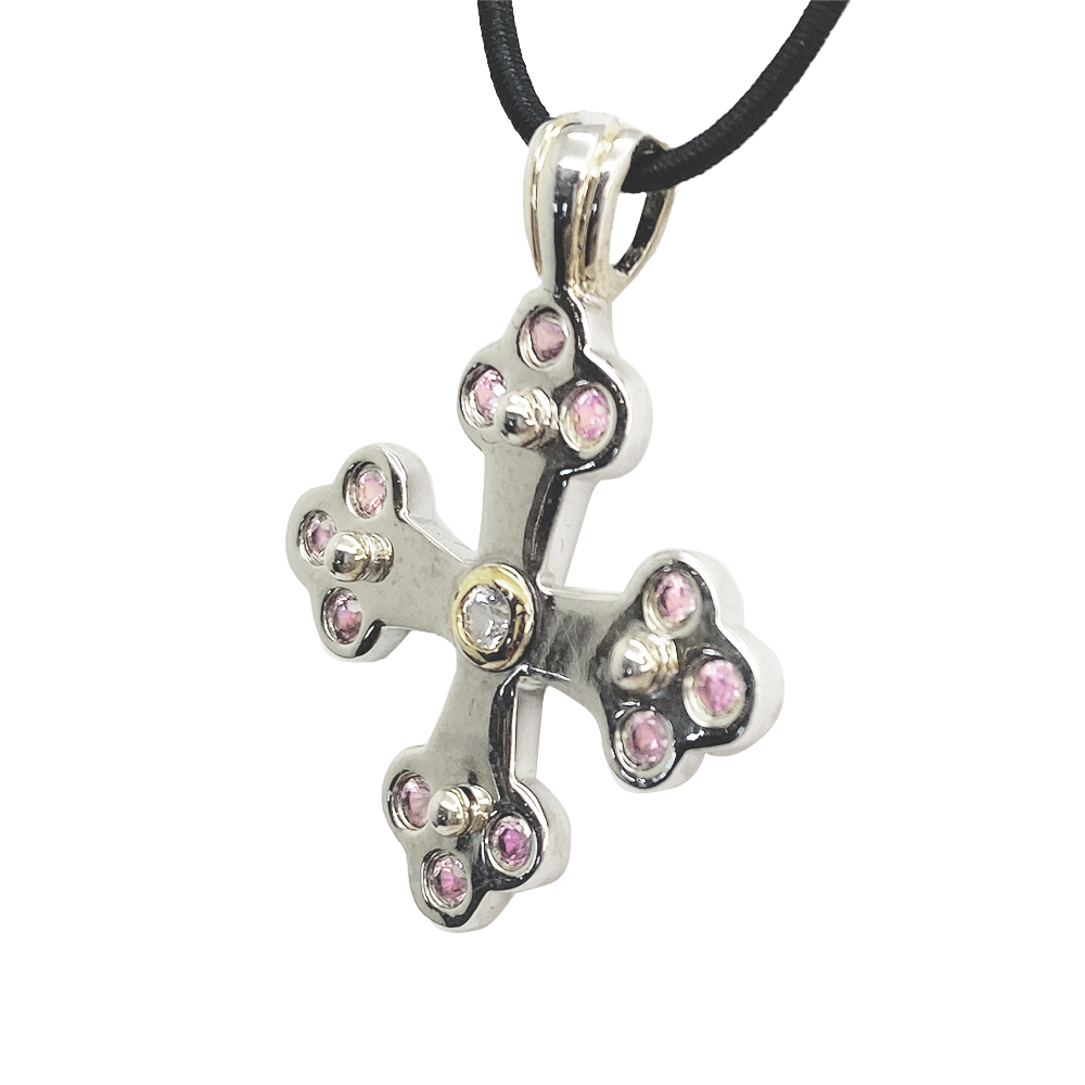 Silver cross pendant with a center gemstone on a white background