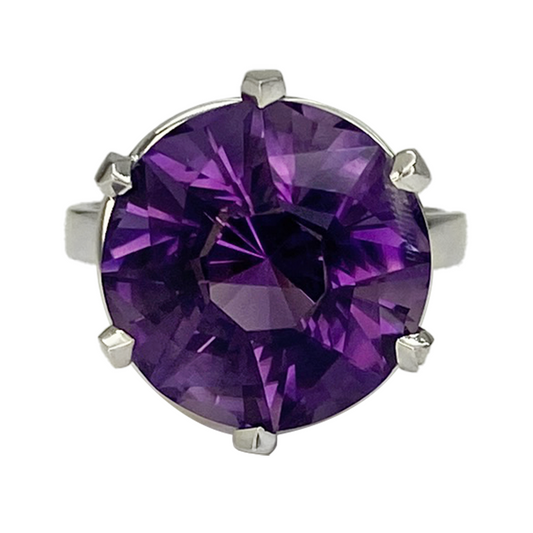 Silver ring with a large, round amethyst in the center.