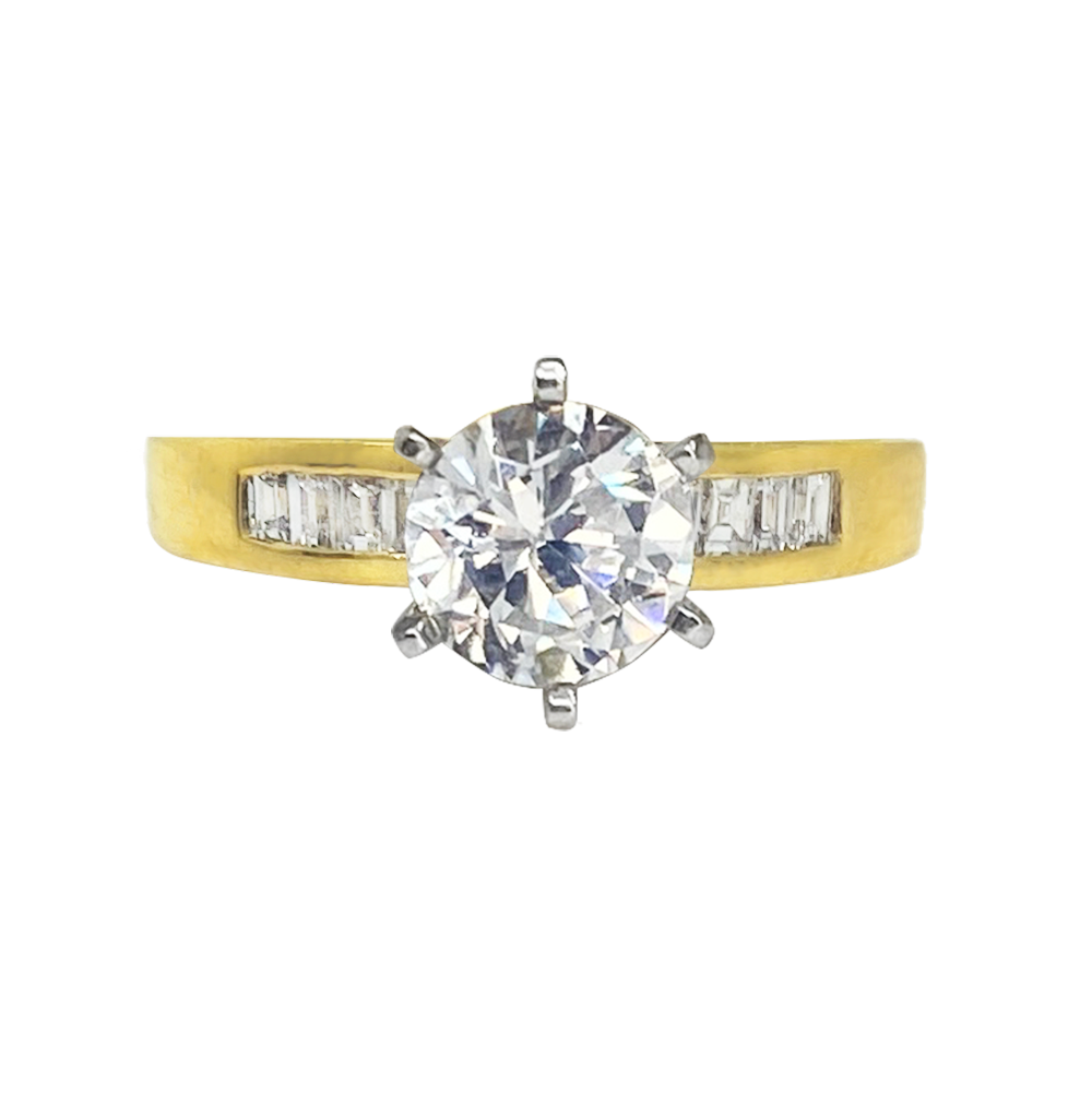 Gold engagement ring with a large, round central diamond. The diamond is held in place by four prongs.