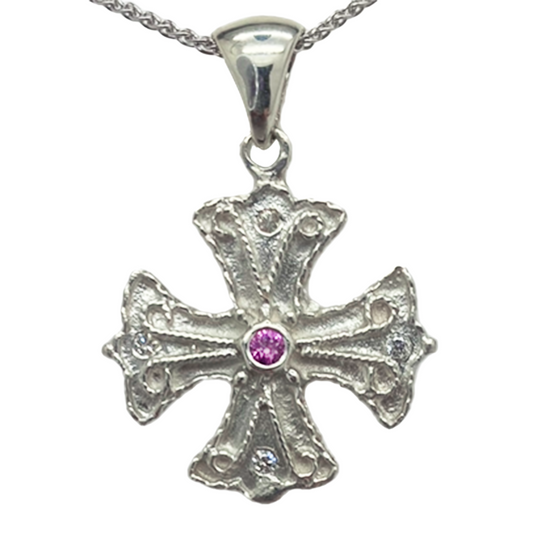 Silver cross pendant with a center gemstone on a white background