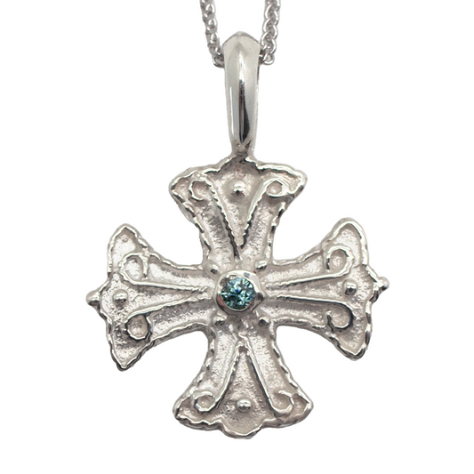 Silver cross pendant with a center gemstone on a white background