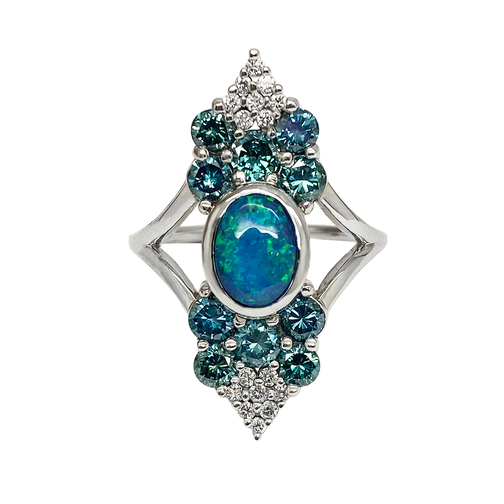 Silver ring featuring a central oval opal surrounded by a cluster of blue sapphires and diamonds.