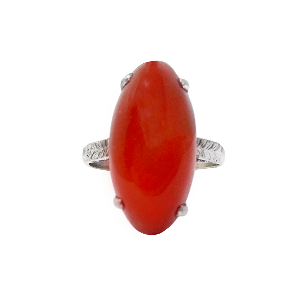 Gold ring featuring an oval carnelian stone with a smooth, polished surface.