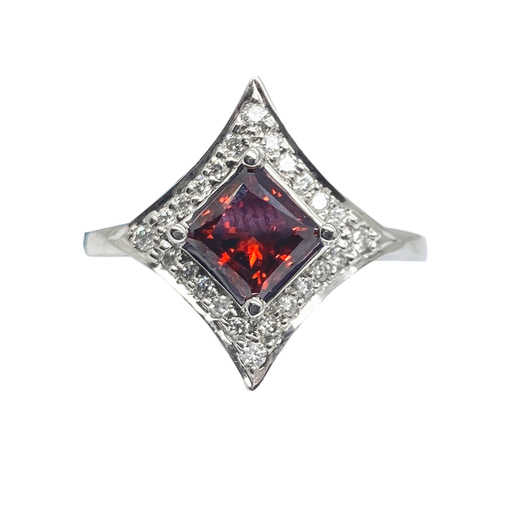 Silver ring featuring a square-cut garnet in the center, surrounded by a halo of smaller diamonds