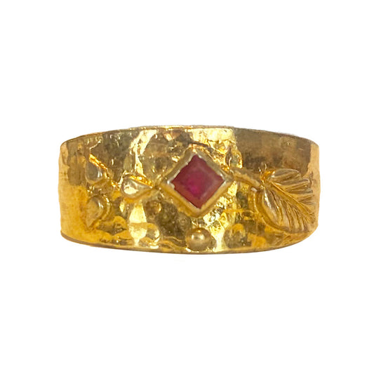  Gold band ring with a square-cut ruby in the center, flanked by leaf-shaped motifs and textured details.