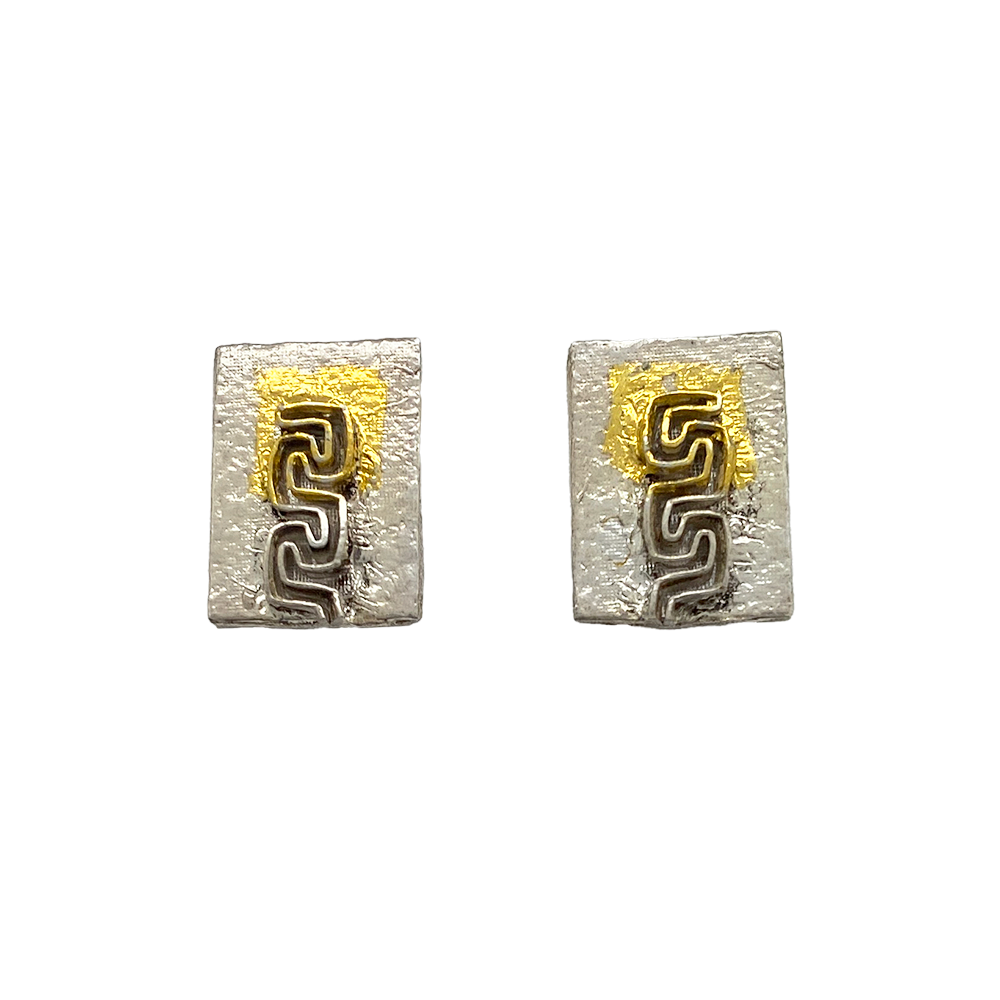 Two square silver earrings with a textured surface, featuring a gold Greek key design