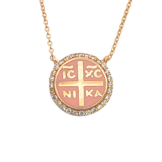 Rose gold pendant necklace with a circular medallion featuring the Greek letters IC XC NIKA in gold, surrounded by a border of clear stones.