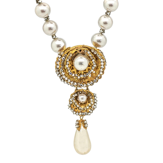 Vintage Miriam Haskell necklace featuring a large faux pearl drop pendant, accented with gold-tone swirls and sparkling rhinestones. 