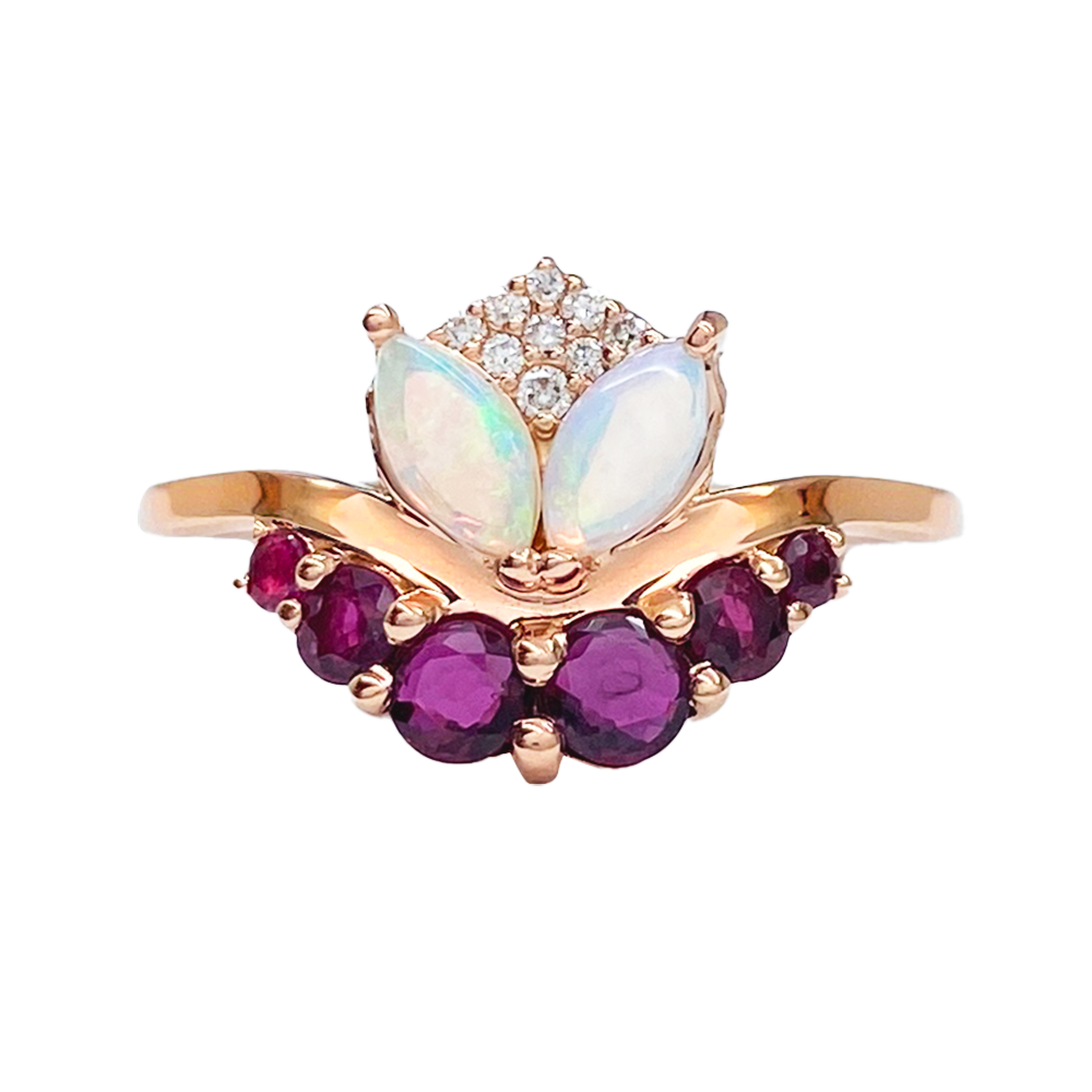 Rose gold ring with two marquise-cut opal gemstones in the center, flanked by smaller opal gemstones and accented with round rubies and diamonds.