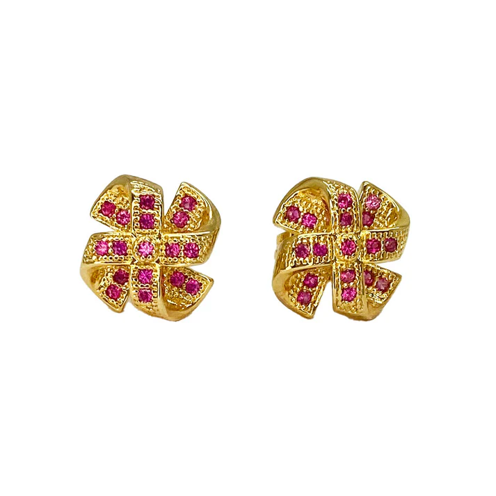 Gold stud earrings with a bow-shaped design featuring ruby gemstones, on a white background.