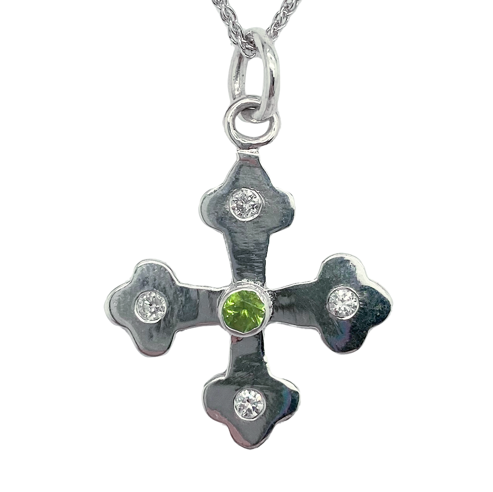 Silver Byzantine Orthodox cross pendant with a central peridot stone and four smaller diamond accents, each set in a four-petaled flower design.