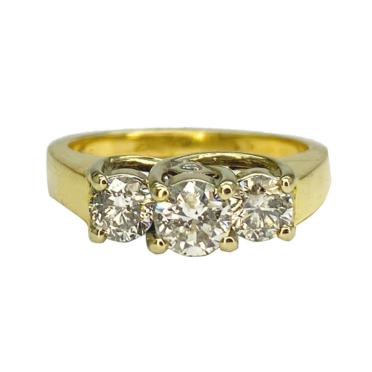 Three-stone diamond ring with a center stone flanked by two smaller stones. 