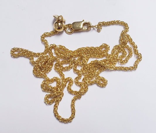 Gold chain necklace resting on a white table