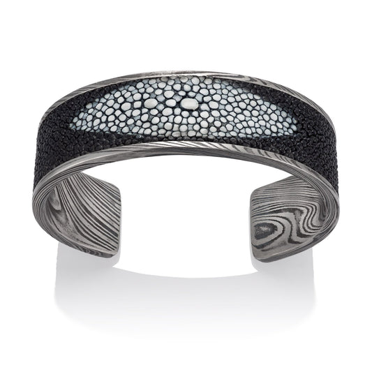 Titanium cuff bracelet with Damascus steel pattern on a white background.