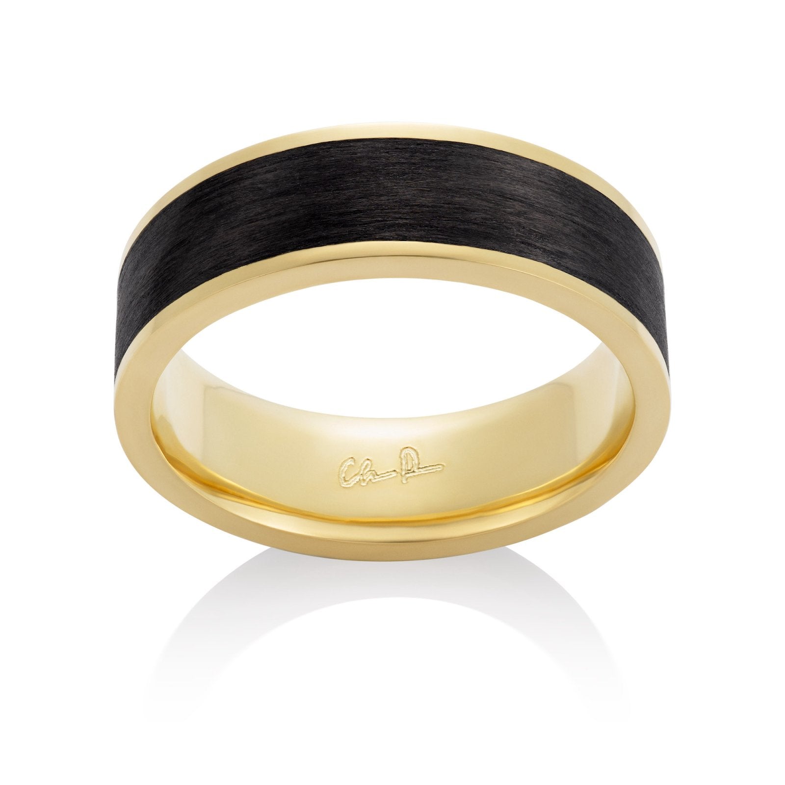 Yellow gold ring with a black carbon fiber inlay on a white background.