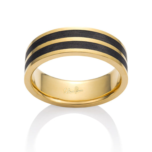 Yellow gold ring with a black carbon fiber inlay on a white background.