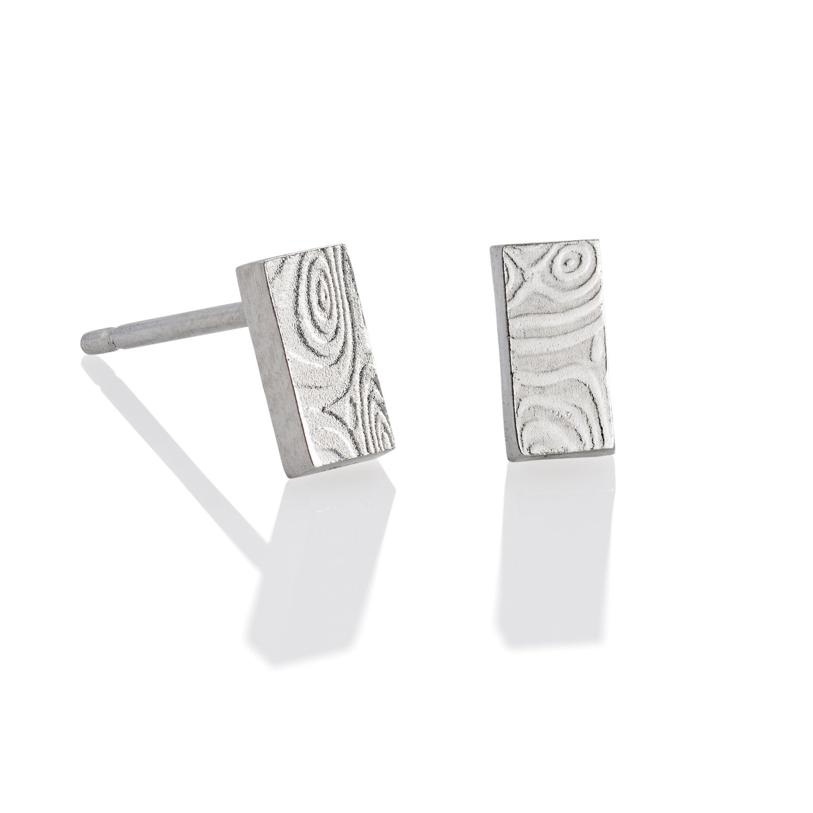 Pair of silver stud earrings with a damascus steel pattern, on a white background.