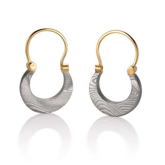 Pair of gold cresent shaped earrings with a damascus steel pattern, on a white background.