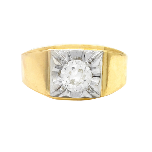 Gold ring with a round diamond in a bezel setting. The ring has a wide band with a flat top and a grooved edge.