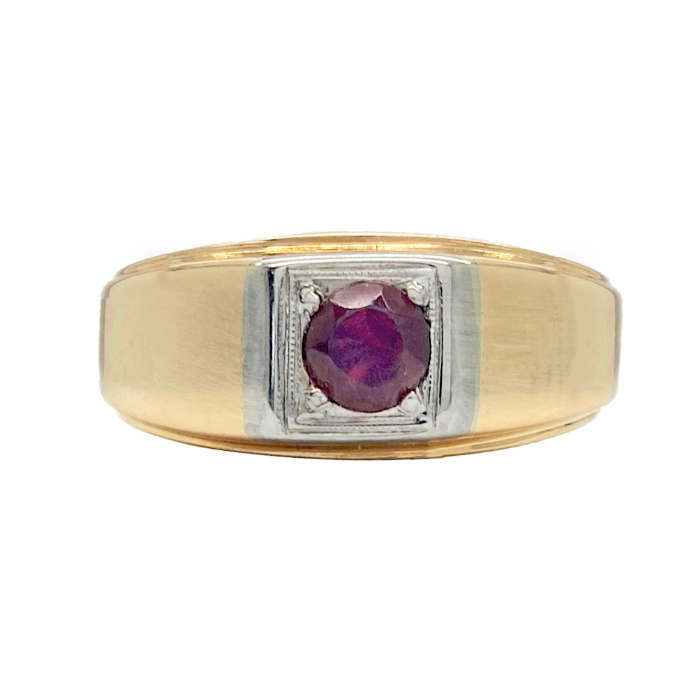 Two-tone men's ring with a red oval gemstone in the center. The ring has a wide band with a flat top and a grooved edge. 