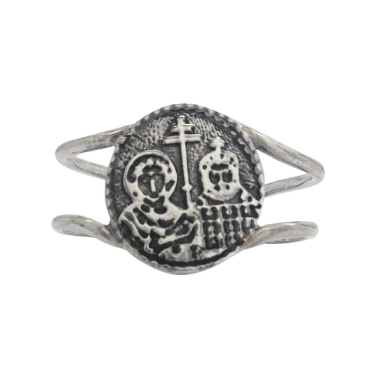 Silver ring featuring a circular medallion with an embossed image of a saint holding a cross and a staff, surrounded by a double-wire band.