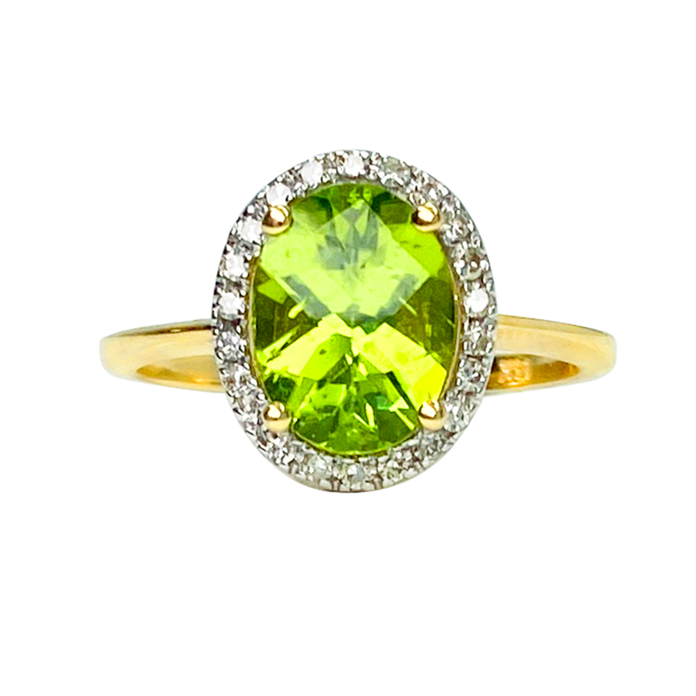 Gold ring with a large green peridot gemstone surrounded by a halo of diamonds on a white background.