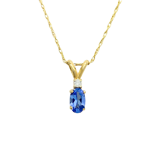 Gold pendant with an oval blue sapphire center stone. The sapphire is surrounded by four prongs and accented with a single diamond above the stone.