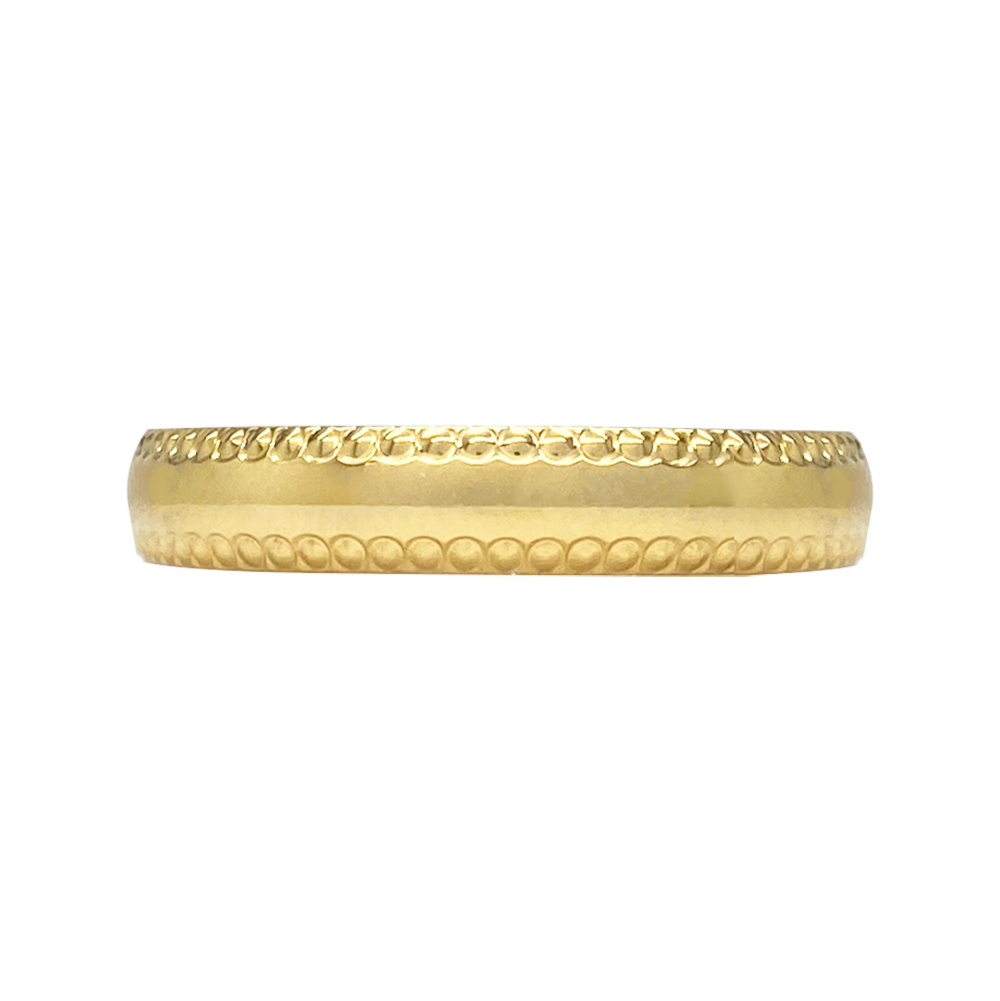 Gold band ring on a white table