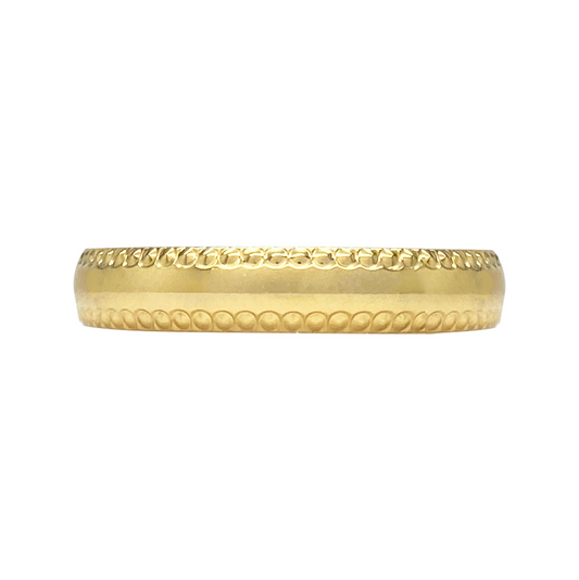 Gold band ring on a white table