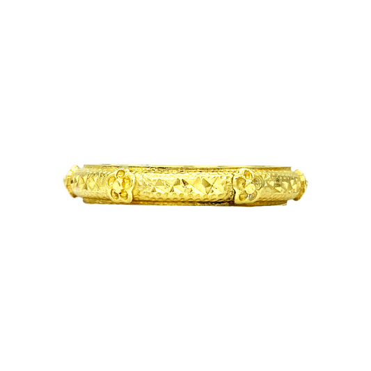 Gold wedding band with engraved floral design.