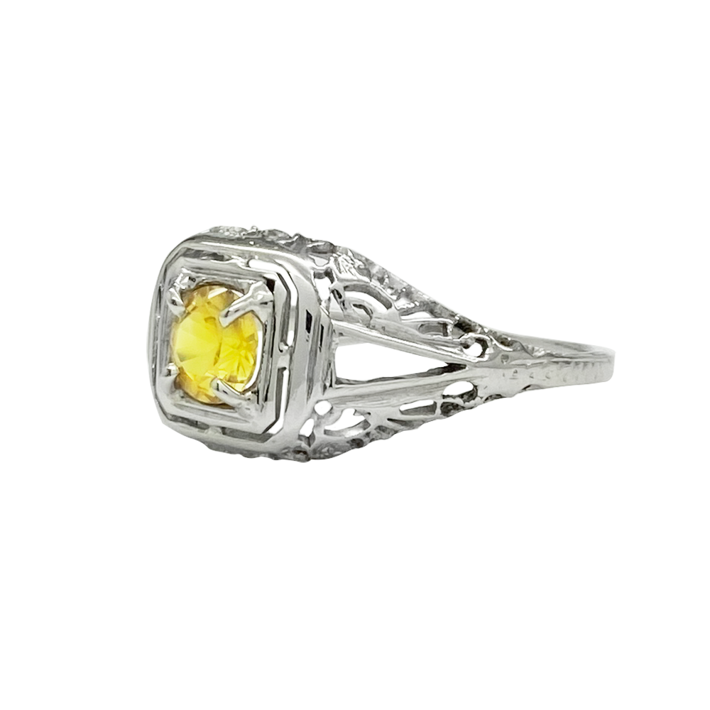  Silver ring with a square yellow sapphire set in a filigree design.