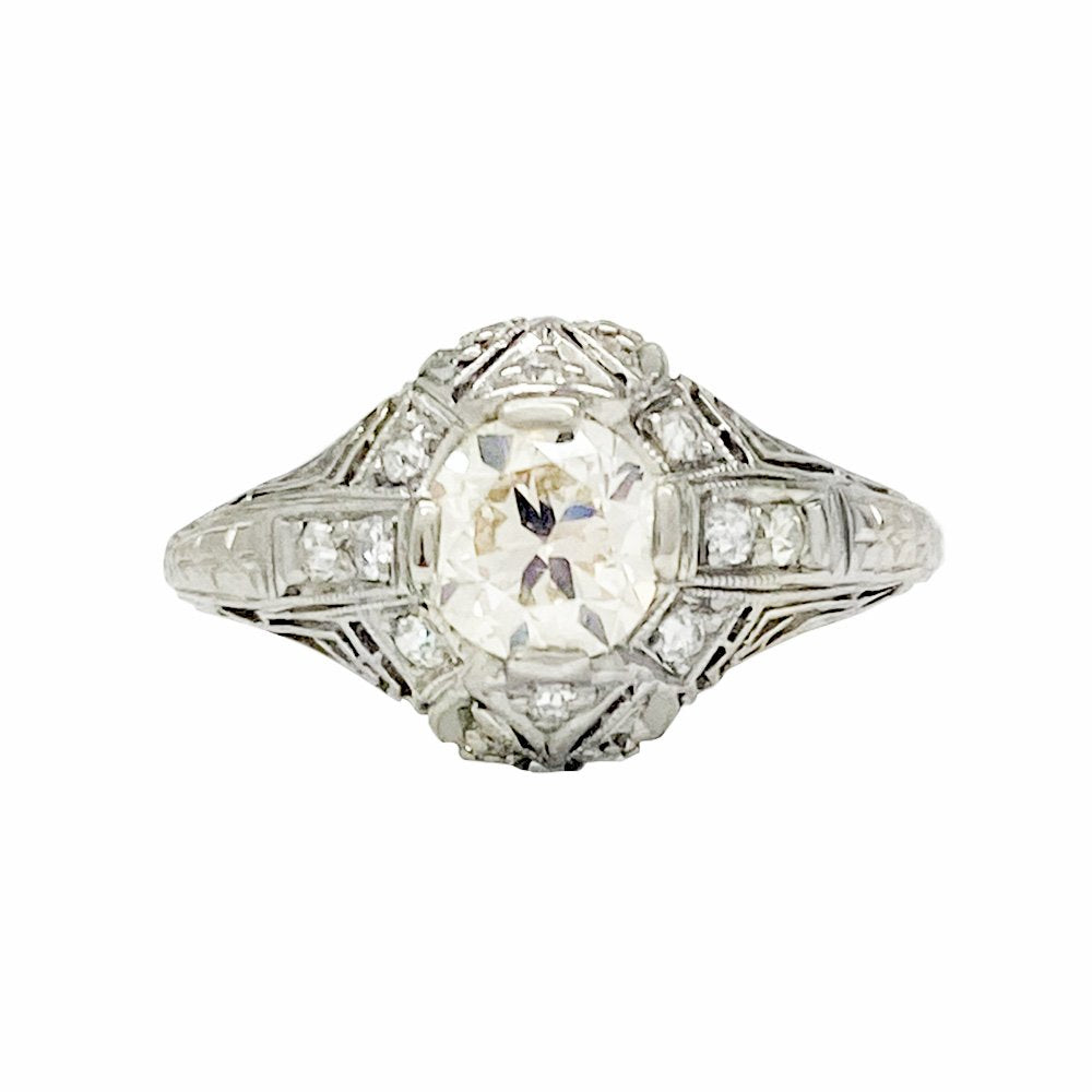 Vintage platinum diamond engagement ring with a filigree setting and a round center stone.