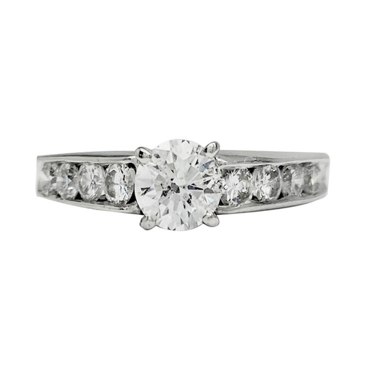 Silver engagement ring with a round center diamond and channel-set diamond side stones.