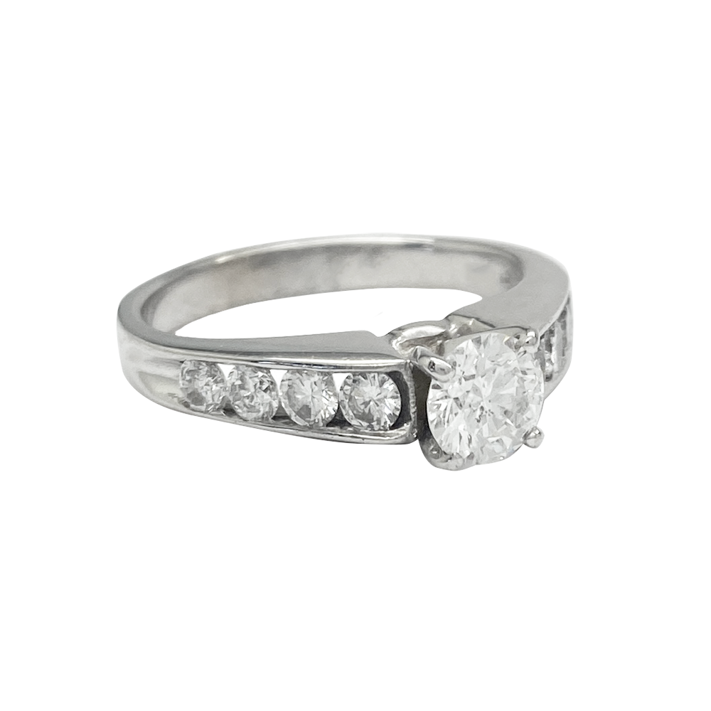 Silver ring with a round center diamond and channel-set diamond side stones.