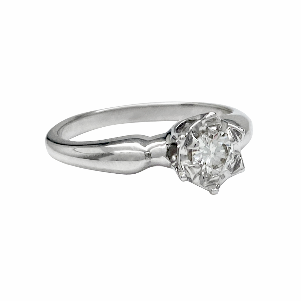 Silver engagement ring with a round center stone and a simple band.