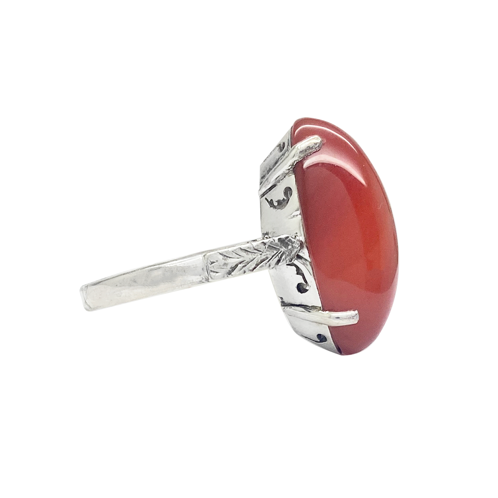 Silver ring featuring a large, oval carnelian stone set in a bezel setting. 