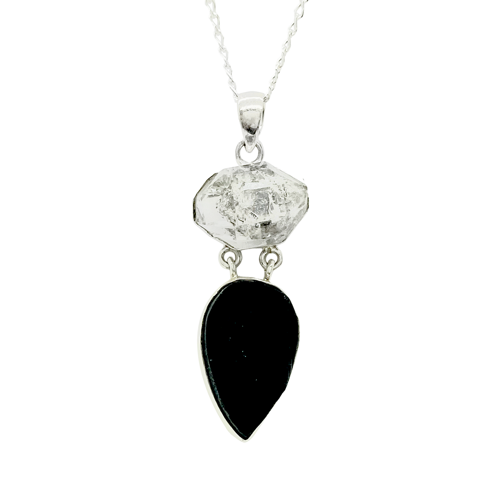 Silver necklace with a geometric quartz pendant and a black onyx teardrop pendant, on a white background