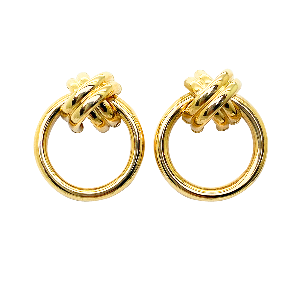 Pair of gold hoop earrings with a knot design on a white background