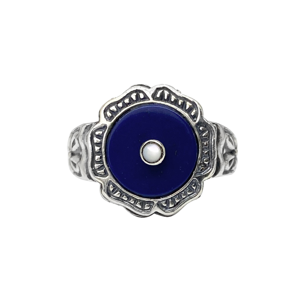 Silver ring with a blue lapis lazuli center stone and intricate filigree detailing, on a white background