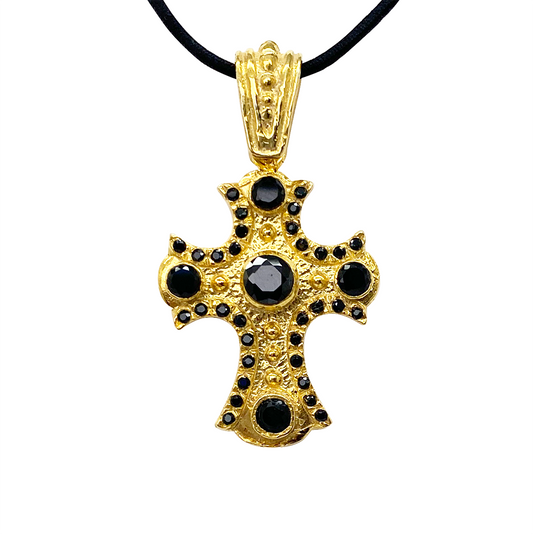 Gold cross pendant with black onyx gemstones on a white background.