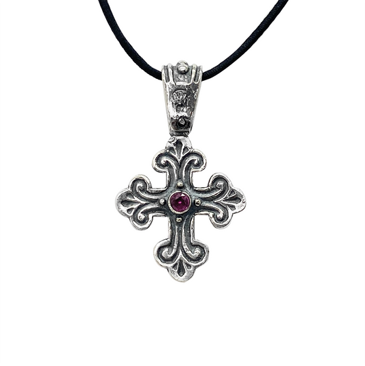 Silver Orthodox cross pendant with a purple gemstone in the center, on a black background