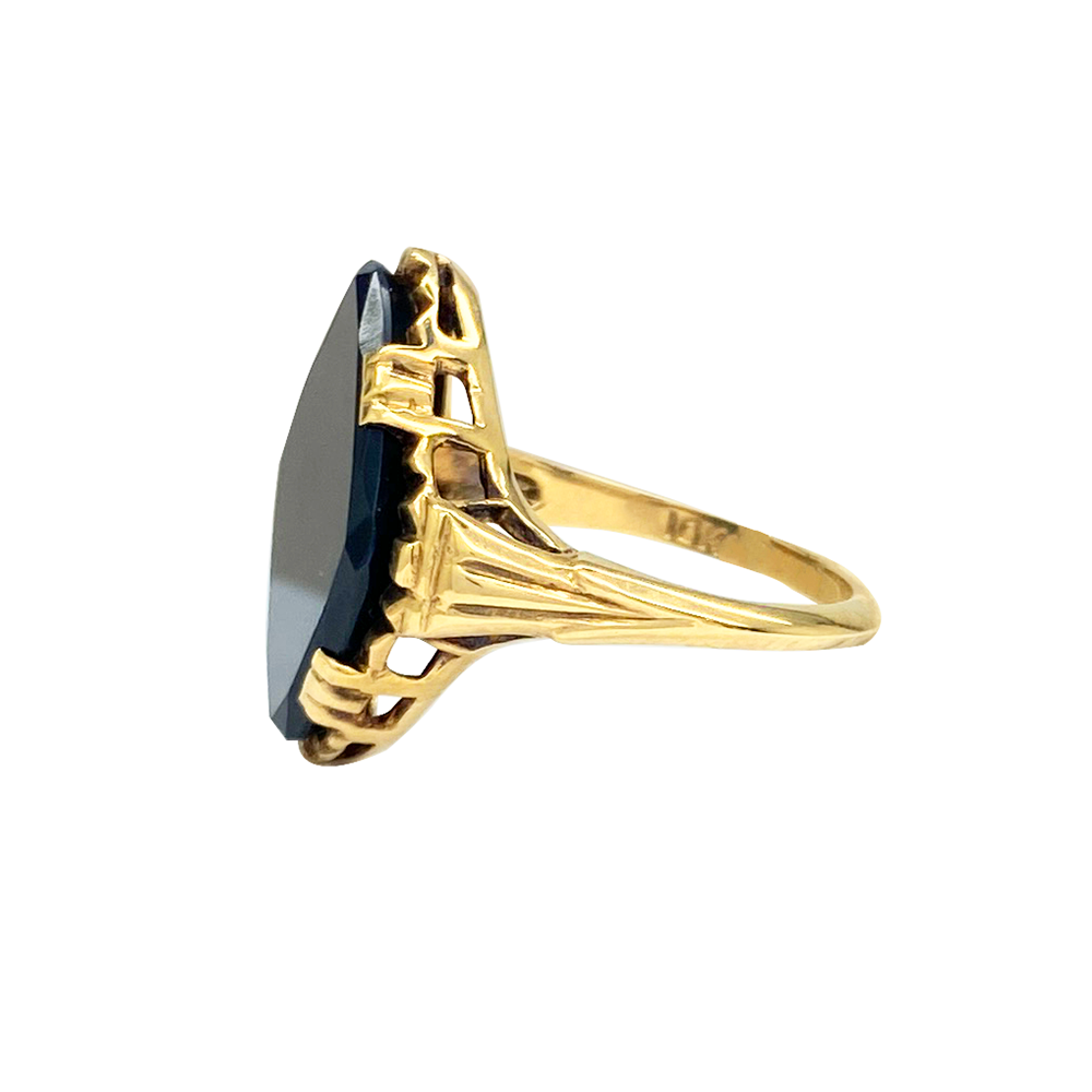 Yellow gold ring with a square black onyx center stone and textured band, on a white background.