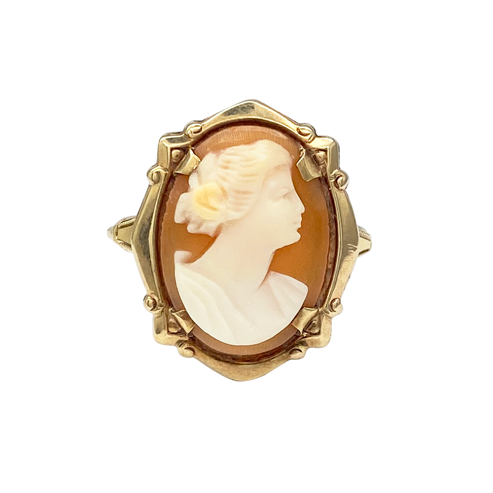 Yellow gold ring with a cameo of a woman's profile carved from shell, on a white background.