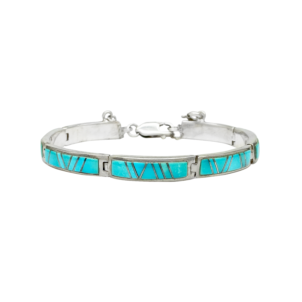 Silver bracelet with turquoise inlay in a geometric pattern, on a white background.