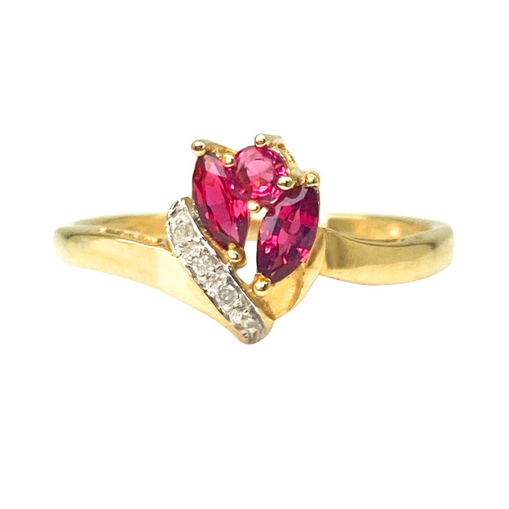 Yellow gold ring with two marquise-cut rubies and diamond accents, on a white background.