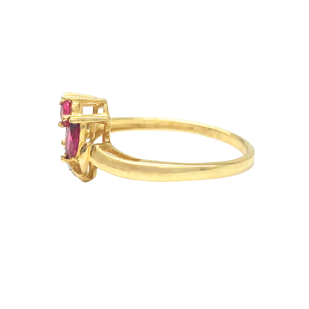 Yellow gold ring with two marquise-cut rubies and diamond accents, on a white background.