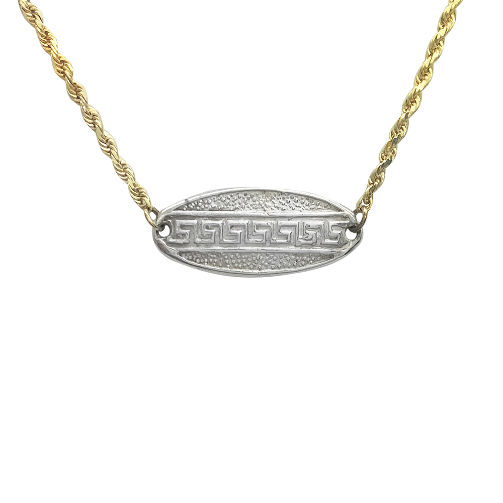 Two-tone gold necklace with a silver oval pendant featuring a Greek key design, on a white background.