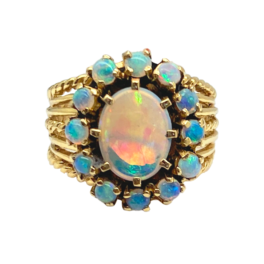 Vintage opal ring with a large oval opal center stone surrounded by smaller opals in a floral arrangement. 