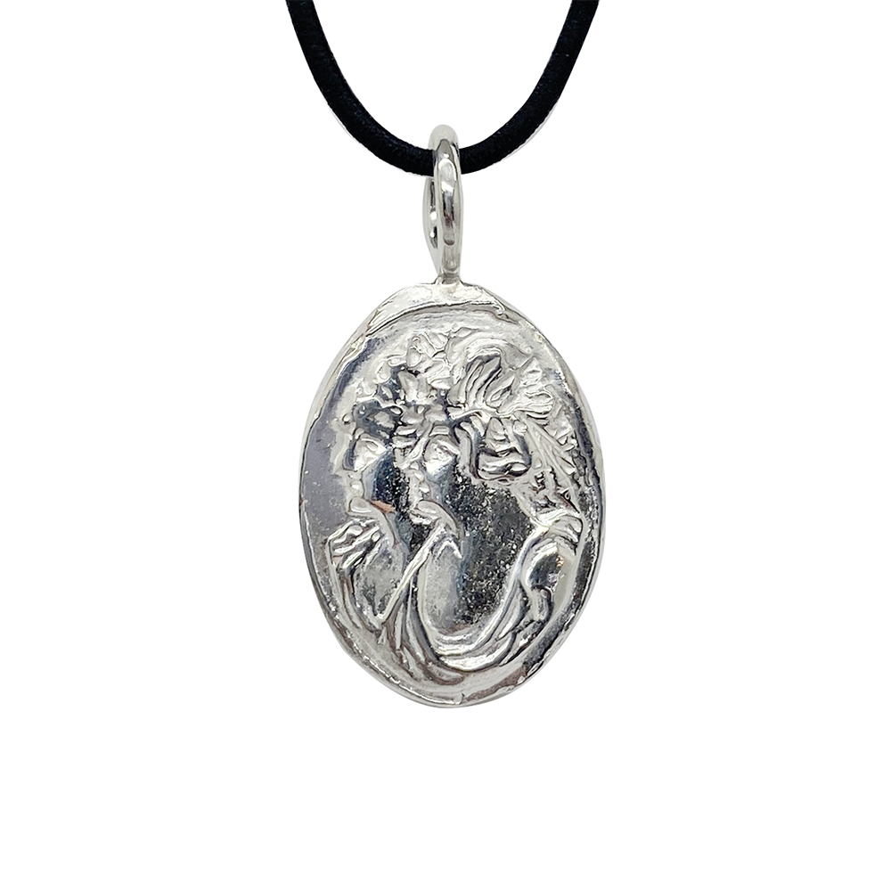 Silver pendant featuring a bas-relief of a woman's head, on a black leather cord, against a white background.